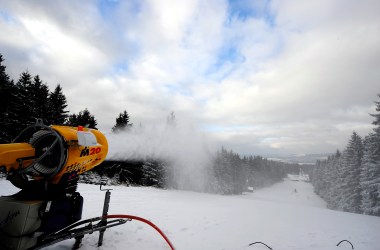 A snow cannon blowing snow onto a ski slope.