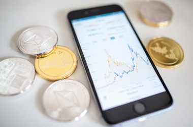 In this photo illustration of the litecoin, ripple and ethereum cryptocurrency "altcoins" sit arranged for a photograph beside a smartphone displaying the current price chart for ethereum on April 25th, 2018, in London, England. Cryptocurrency markets began to recover this month following a massive crash during the first quarter of 2018, seeing more than $550 billion wiped from the total market capitalization.