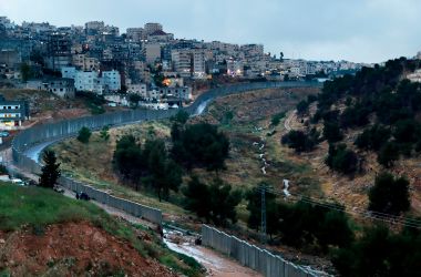 Palestinians from the Shuafat refugee camp stand on part of the separation wall on April 26th, 2018, after it collapsed due to heavy rainfall and floods.