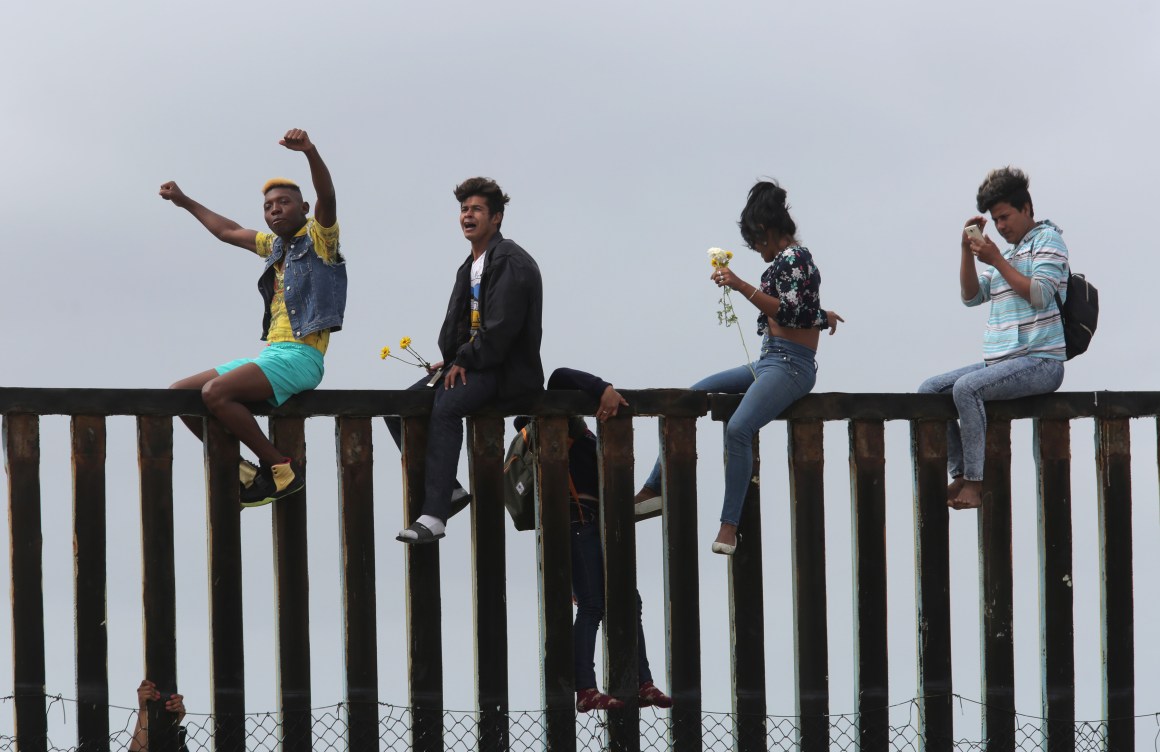 Pro-migrant caravan demonstrators rally on the Mexican side of the border wall on April 29th, 2018, in San Diego, California.