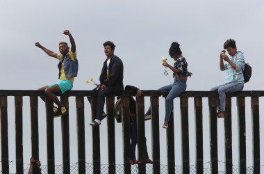 Pro-migrant caravan demonstrators rally on the Mexican side of the border wall on April 29th, 2018, in San Diego, California.