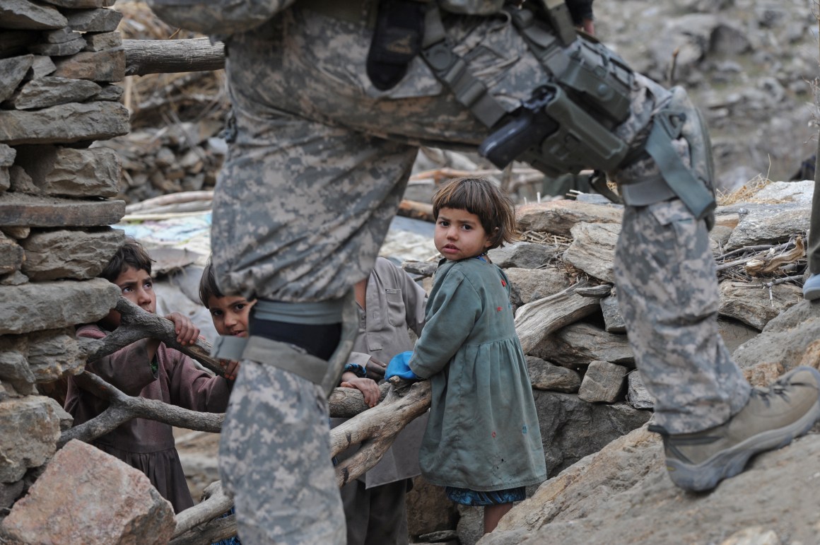 Afghan children look at a U.S. soldier in the mountains of Nuristan Province on December 19th, 2009.