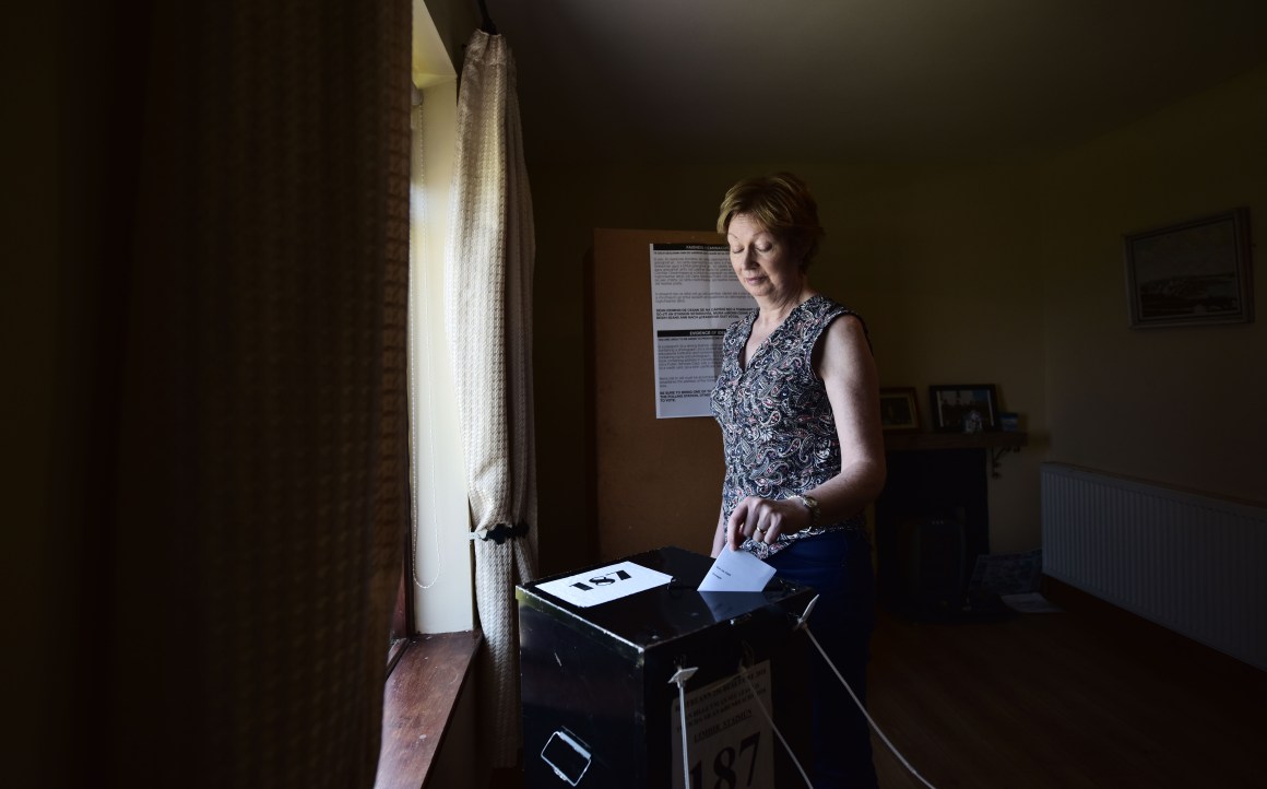 Maureen Ui Fhearraigh casts her ballot paper as voting takes place a day earlier than on the mainland, on May 24th, 2018, in Gola Island, Ireland.