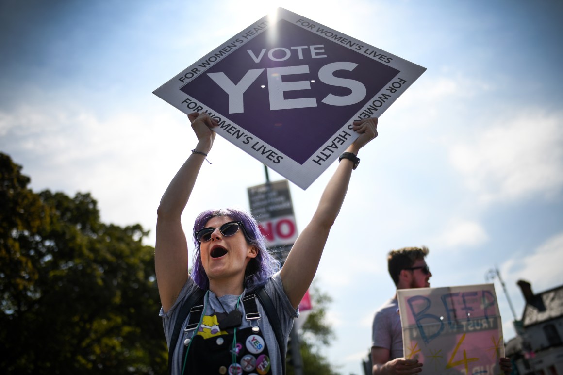 Members of the public hold "yes" placards on Fairview road as the country heads to polling stations.