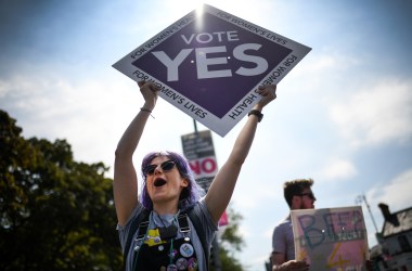 Members of the public hold "yes" placards on Fairview road as the country heads to polling stations.