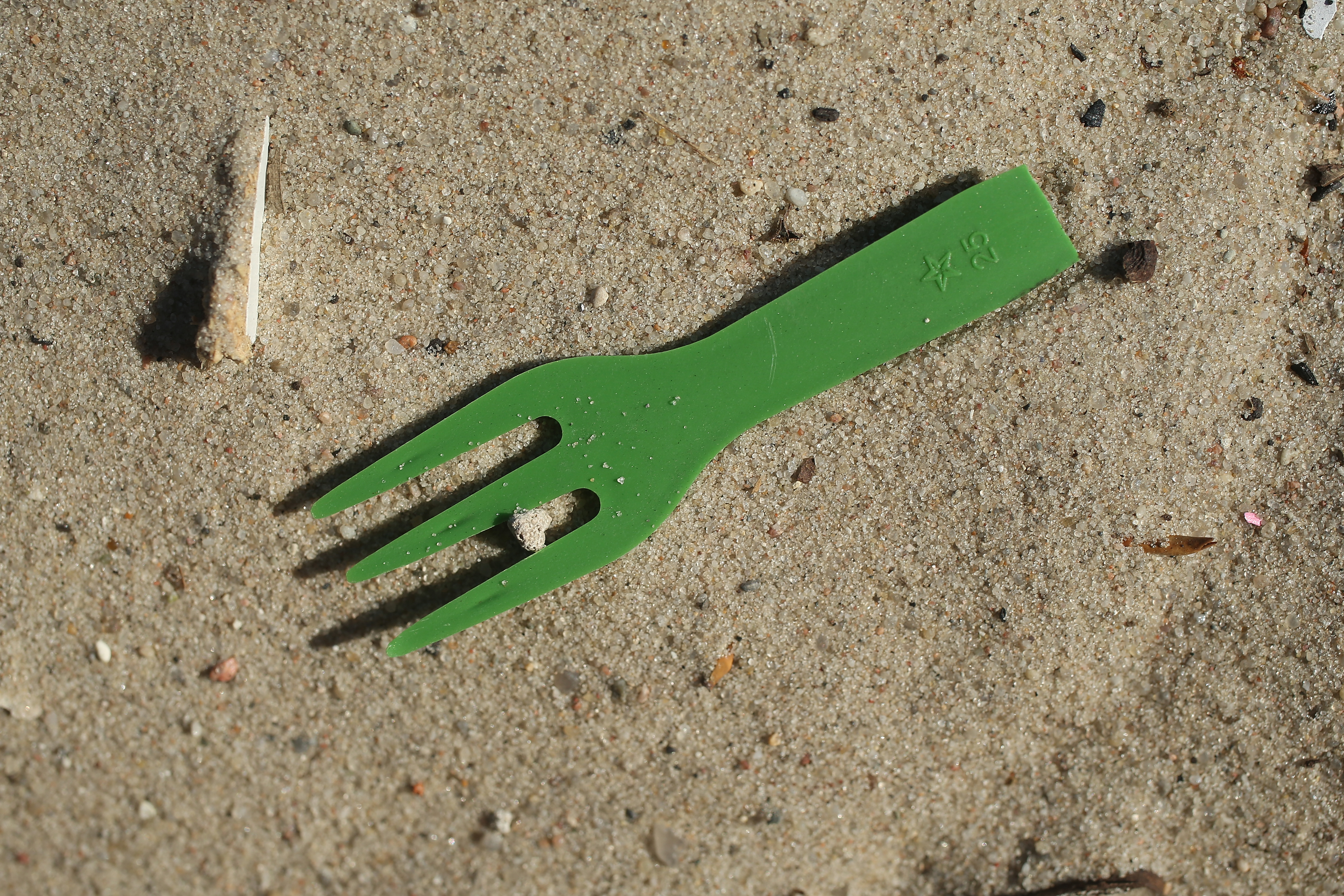 A plastic fork lies on a beach along the Spree River in the city center on May 29th, 2018, in Berlin, Germany. Europe is struggling to combat plastics pollution in its waterways and seas. It recently announced it will seek to ban the use of certain common plastic items, including plastic cutlery, straws, plates, swabs, and fishing gear.