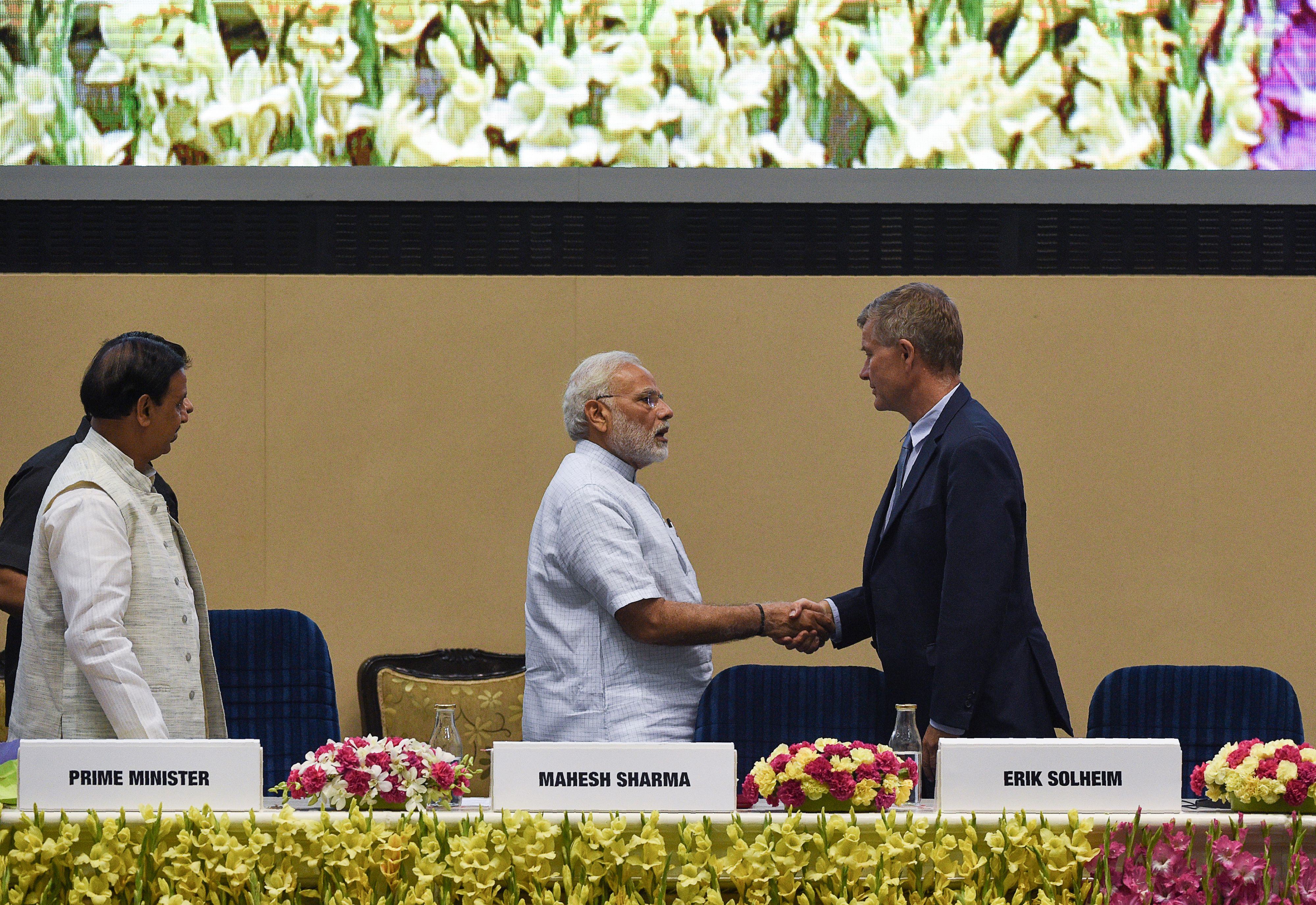 India's Prime Minister Narendra Modi (C) shakes hands with United Nations environment chief Erik Solheim during a plenary session on the occasion of World Environment Day in New Delhi on June 5th, 2018.