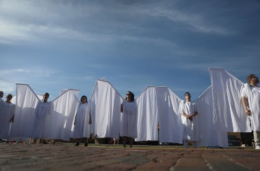 People dressed as angels stand in front of the memorial set up for the shooting victims at Pulse nightclub on June 12th, 2018, where the shootings took place two years ago in Orlando, Florida.