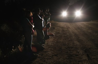 Central American asylum seekers wait for transport while being detained by U.S. Border Patrol agents near the U.S.-Mexico border on June 12th, 2018, in McAllen, Texas. The group of women and children had rafted across the Rio Grande from Mexico and were detained before being sent to a processing center for possible separation.