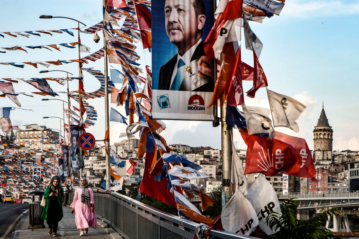 Women walk on a bridge past campaign banners with the portrait of Turkey's president in Istanbul on June 18th, 2018. Turkey prepares for tight presidential and parliamentary elections on June 24th, while many analysts say President Recep Tayyip Erdogan wants a major foreign policy success to give him a final boost. The slogan reads "A big Turkey wishes a powerful leader."