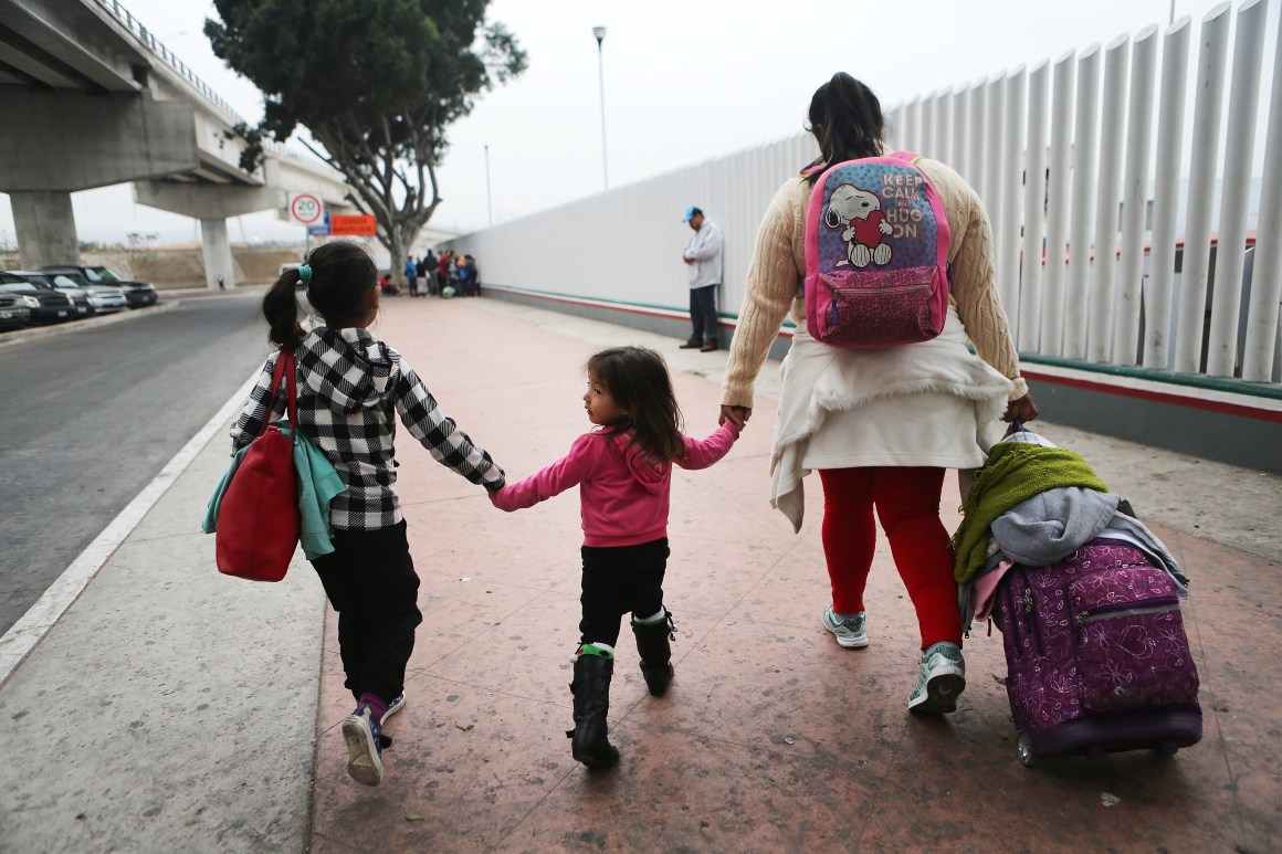 A migrant mother walks with her two daughters on their way to cross the port of entry into the U.S. for their asylum hearing on June 21st, 2018, in Tijuana, Mexico.