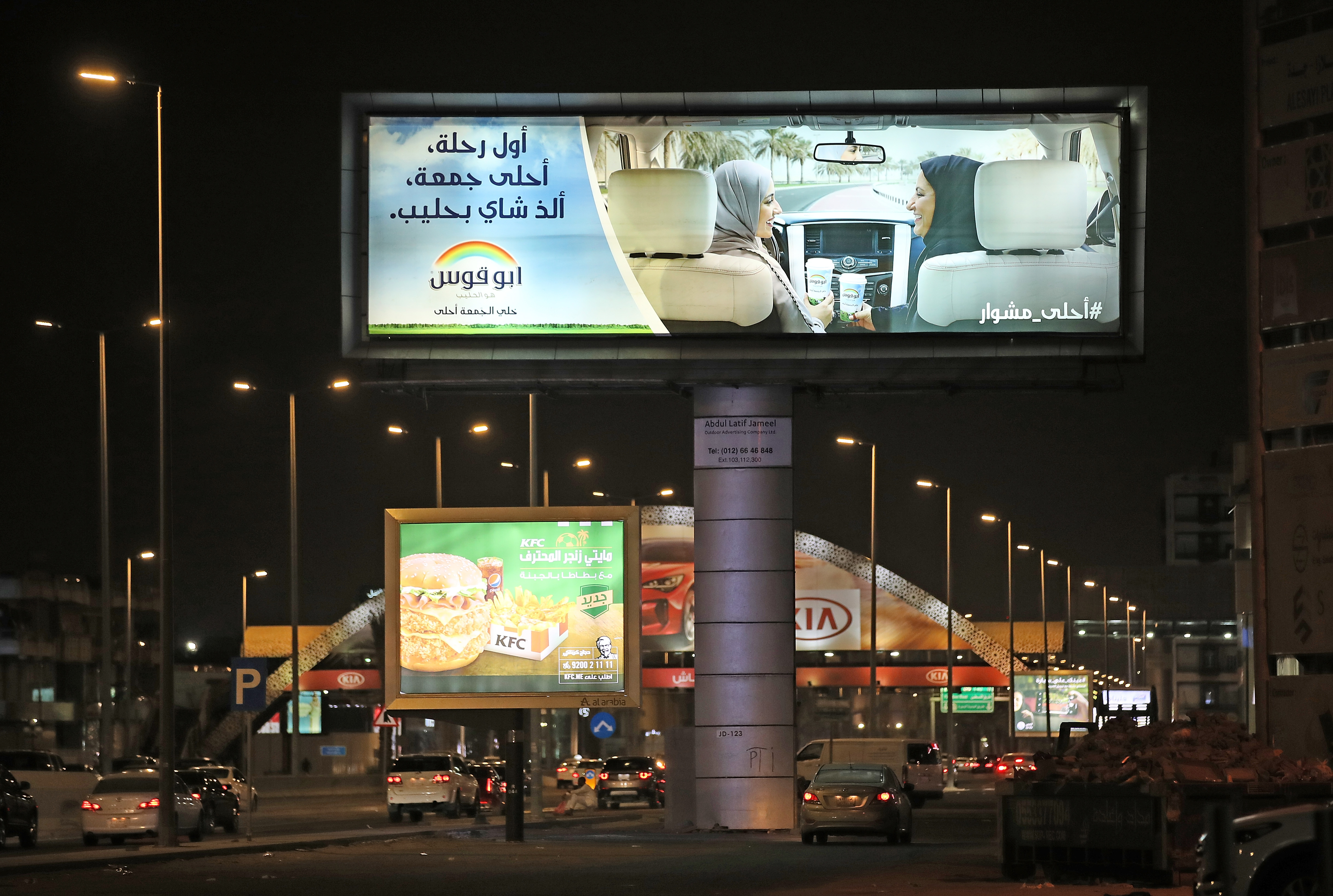 A commercial advertising billboard shows two women in a car with one behind the wheel on June 21st, 2018, in Jeddah.