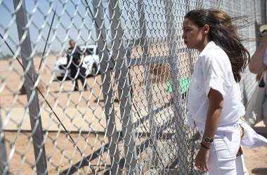 Alexandria Ocasio-Cortez stands at the Tornillo-Guadalupe port of entry gate on June 24th, 2018, in Tornillo, Texas.