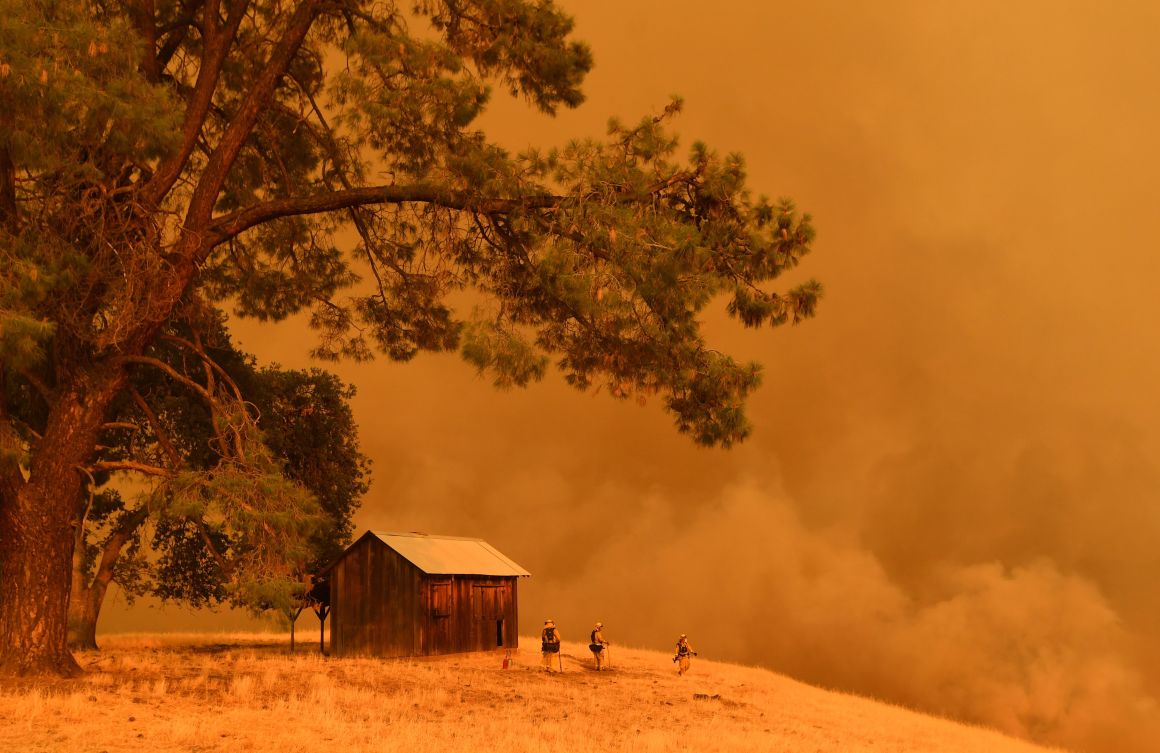 Firefighters watch as flames from the County Fire climb a hillside in Guinda, California, on July 1st, 2018.