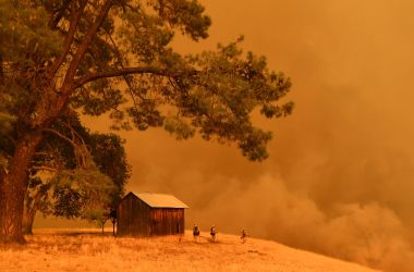 Firefighters watch as flames from the County Fire climb a hillside in Guinda, California, on July 1st, 2018.