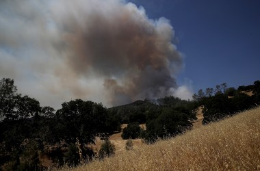 Smoke rises from the County Fire as it burns through dry brush on July 2nd, 2018, in Guinda, California.