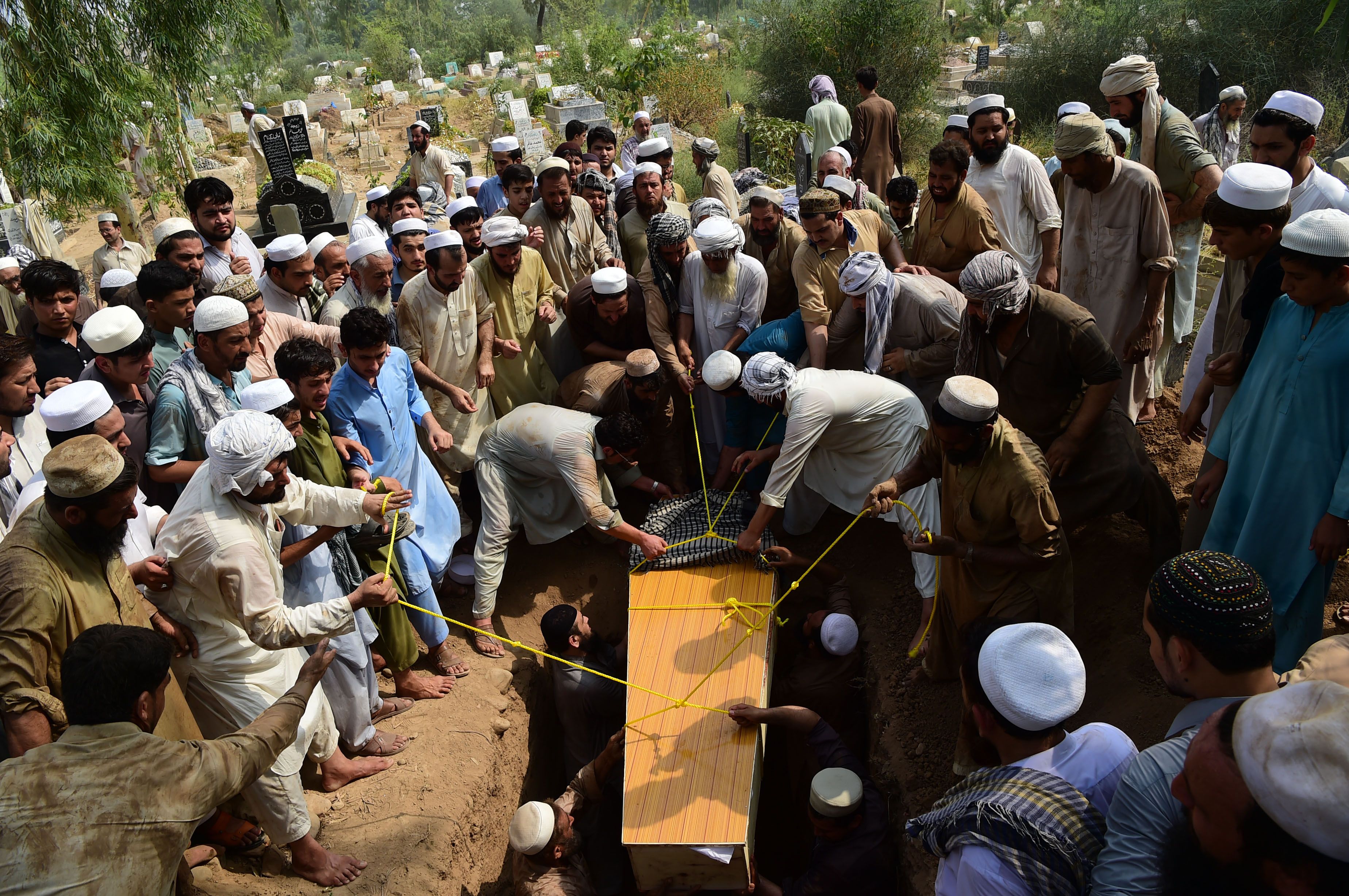 Pakistani residents bury a blast victim, killed in a suicide bombing at an election rally, during a funeral in Peshawar on July 11th, 2018.