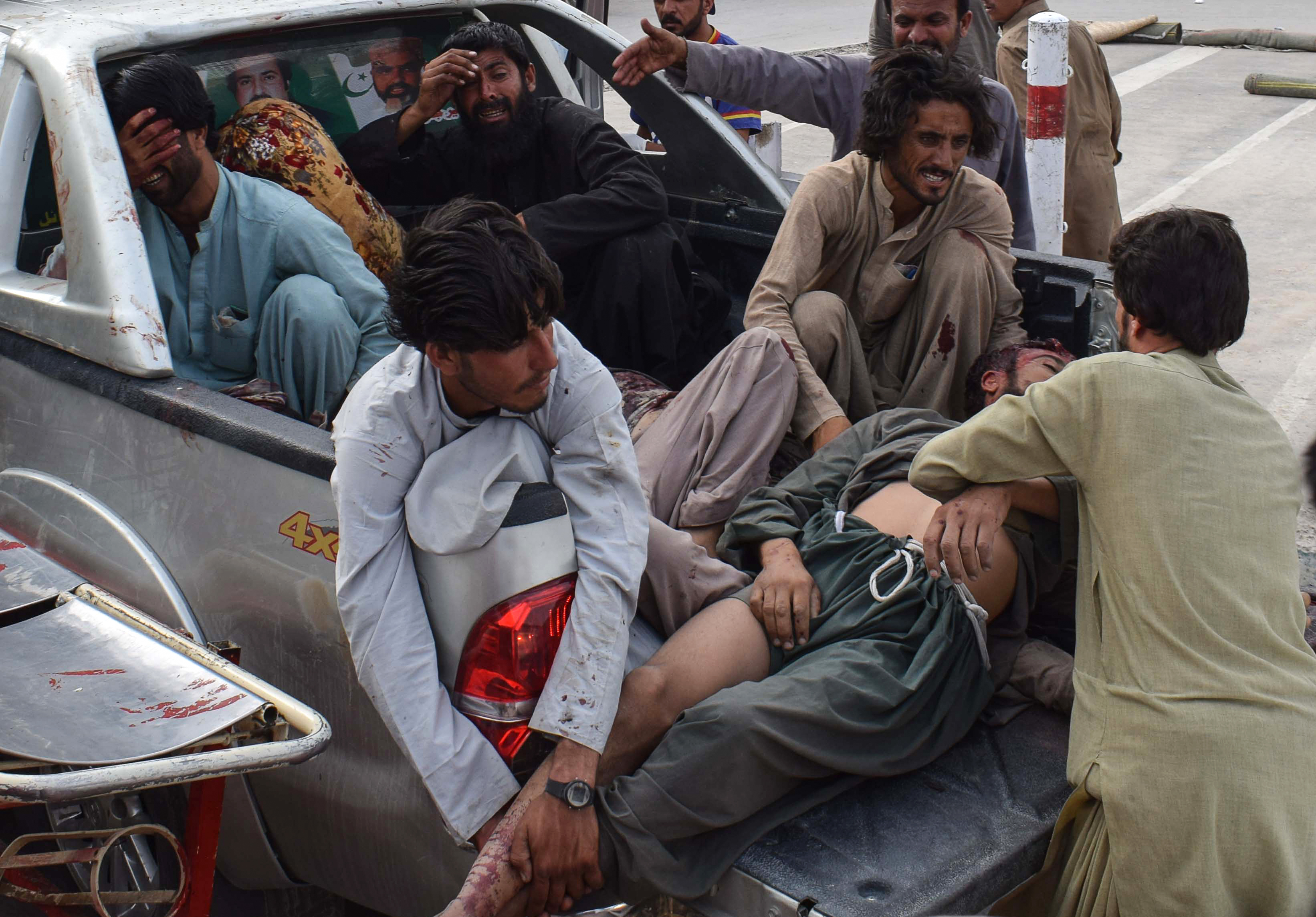 Pakistani men bring the victim of a bomb blast to a hospital in Quetta on July 13th, 2018.