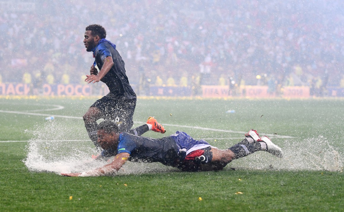 Presnel Kimpembe and Thomas Lemar of France celebrate in the rain after victory in the 2018 FIFA World Cup final between France and Croatia at Luzhniki Stadium on July 15th, 2018, in Moscow, Russia.