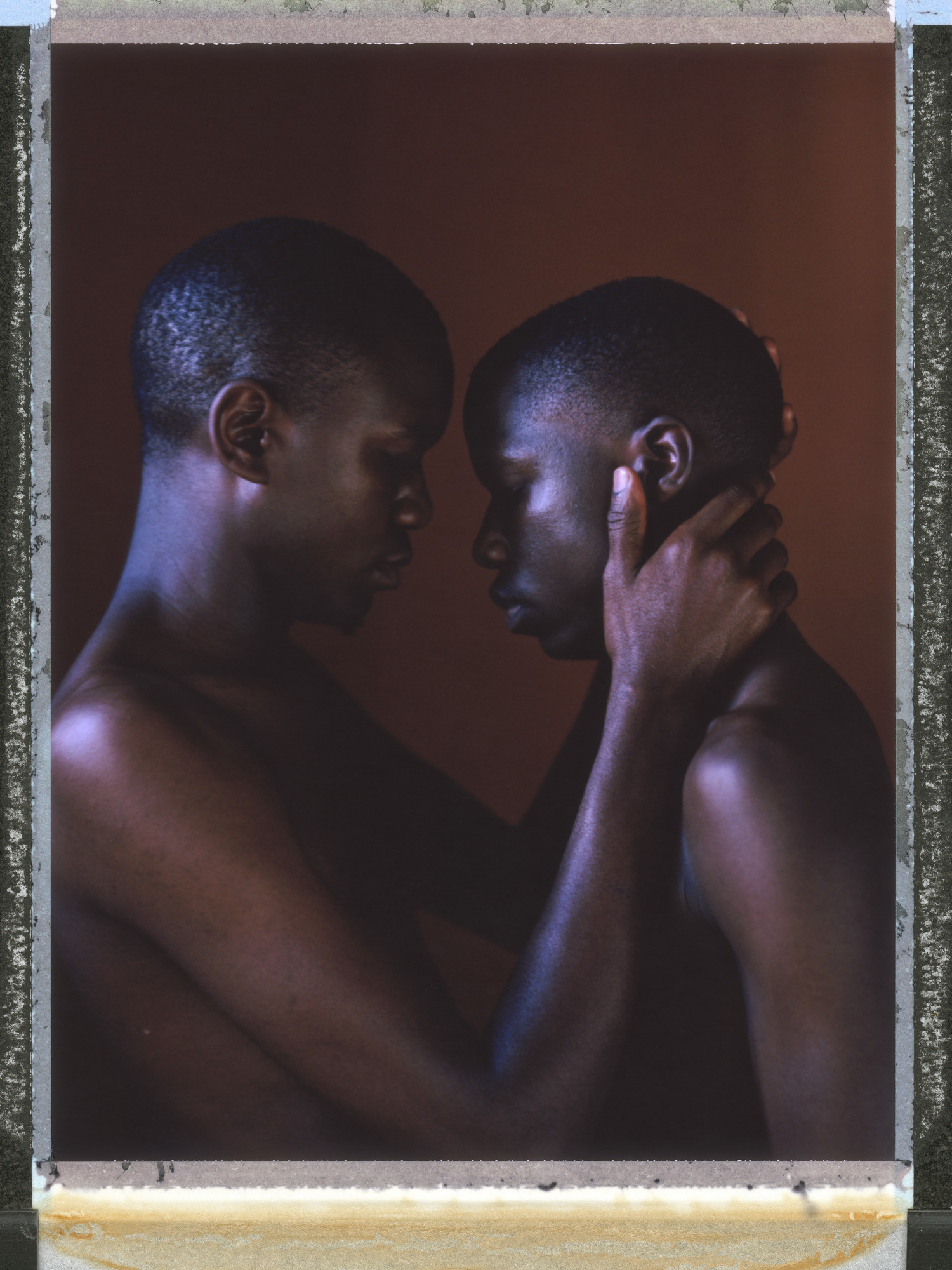 A posed portrait of 25-year-old Miiro (left) and 21-year-old Imran (right, not his real name), a gay couple living together in Uganda that spent time in prison before being released by human rights lawyers.