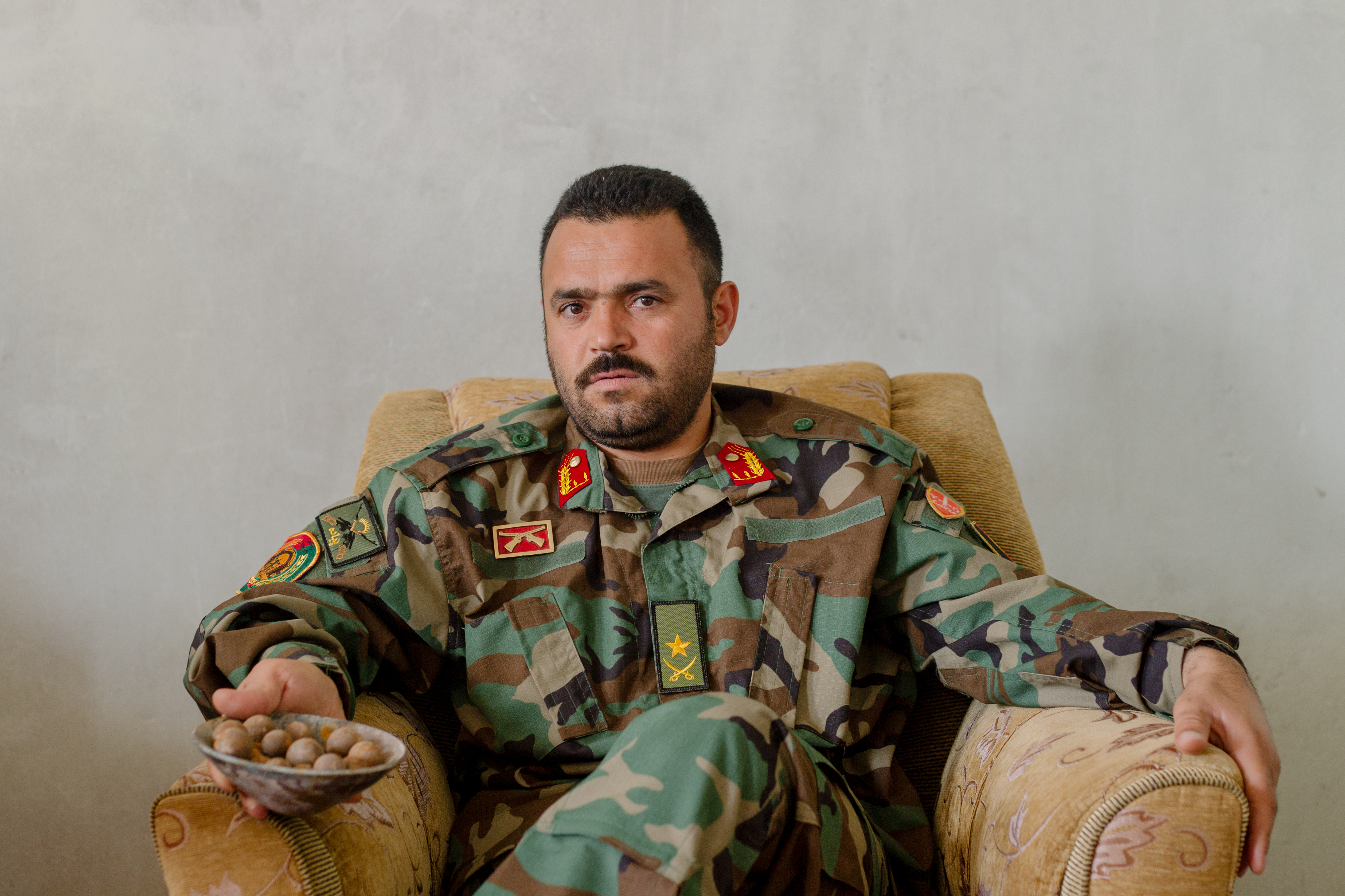 Afghan National Army Major Hedayat Rasouly sits in his office in April of 2019 holding the remains of a shaped charge bomb. The bomb was planted by the Taliban and later defused by explosive ordinance disposal specialists from Rasouly's brigade.