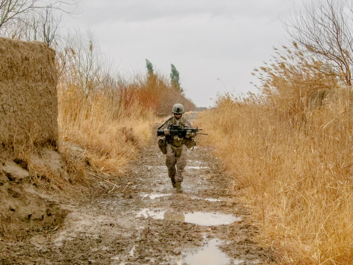 A Marine from the author's squad walks down a muddy goat trail on patrol in Marjah during the spring of 2011.