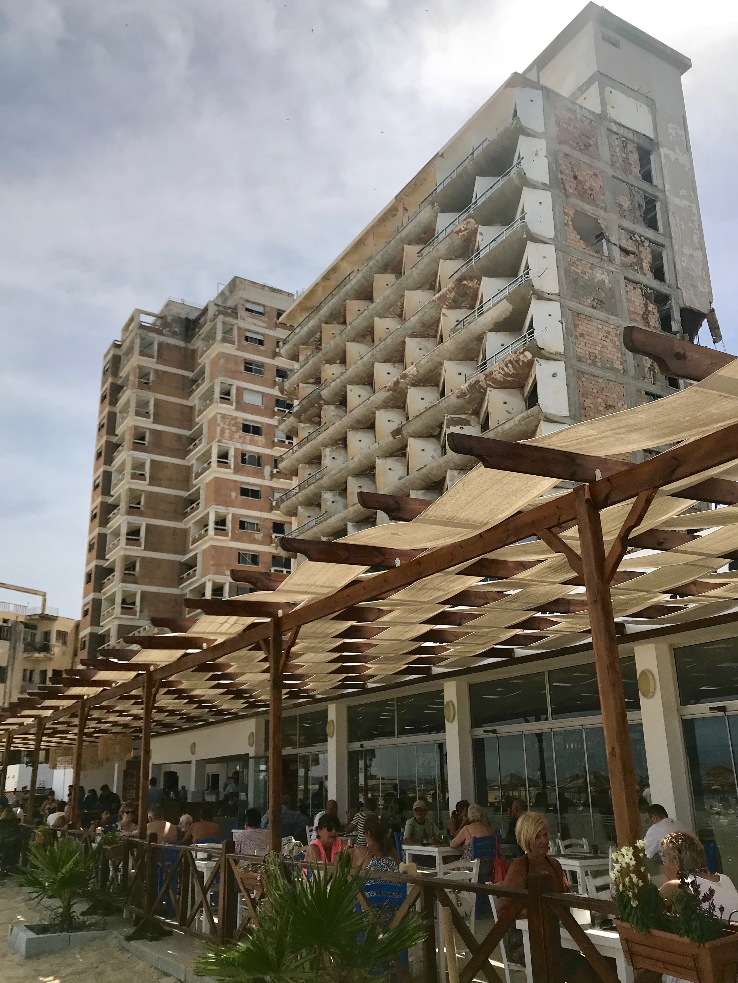 A trendy café in Famagusta with crumbling buildings in the background.