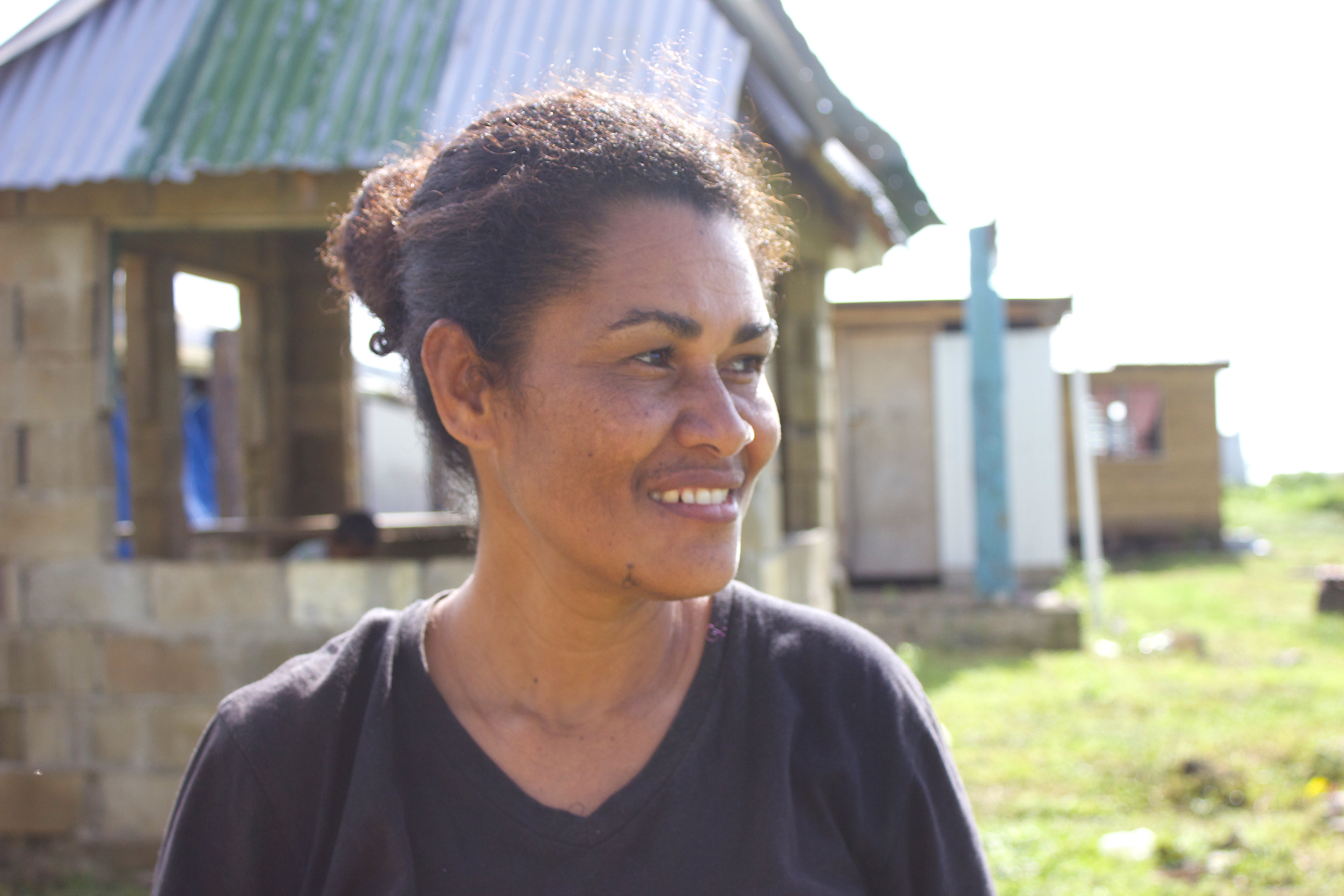 In Nasau, on Koro island, La Venia stands in front of houses that are still being rebuilt.