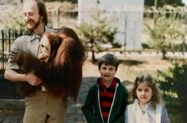 Zookeeper Dick Haskin poses for a photo with Chewy, a sumatran orangutan, and two young visitors at the Lincoln Children’s Zoo.