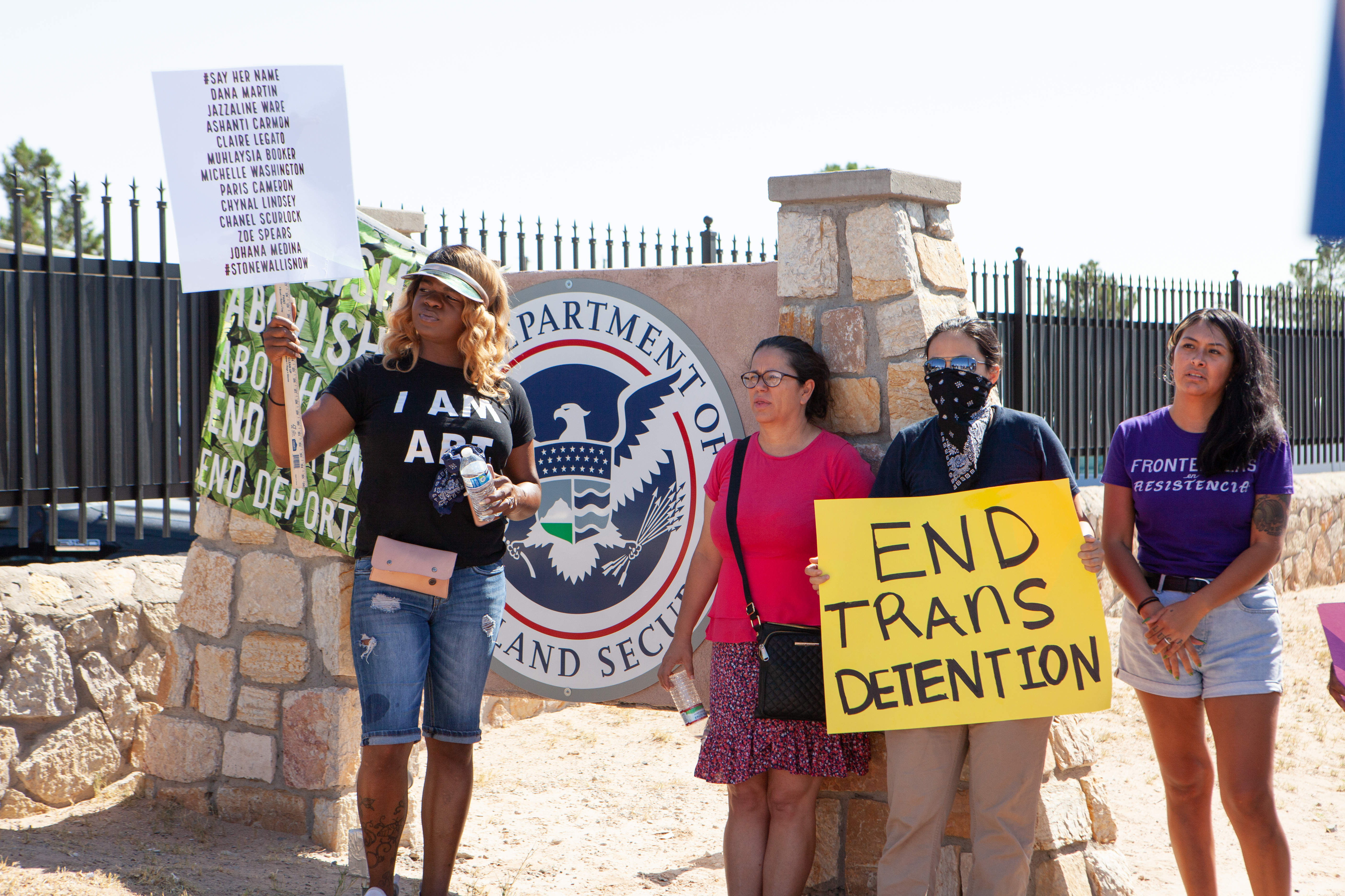 Protesters gather outside the El Paso Processing Center, an ICE facility, near a sign bearing the insignia of the Department of Homeland Security, ICE's parent agency.