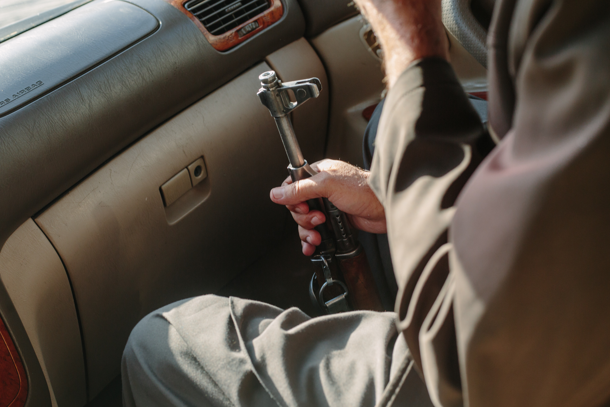 A member of Nasib's campaign team clutches an AK-47 while the team drives through Kabul, days before the parliamentary election.