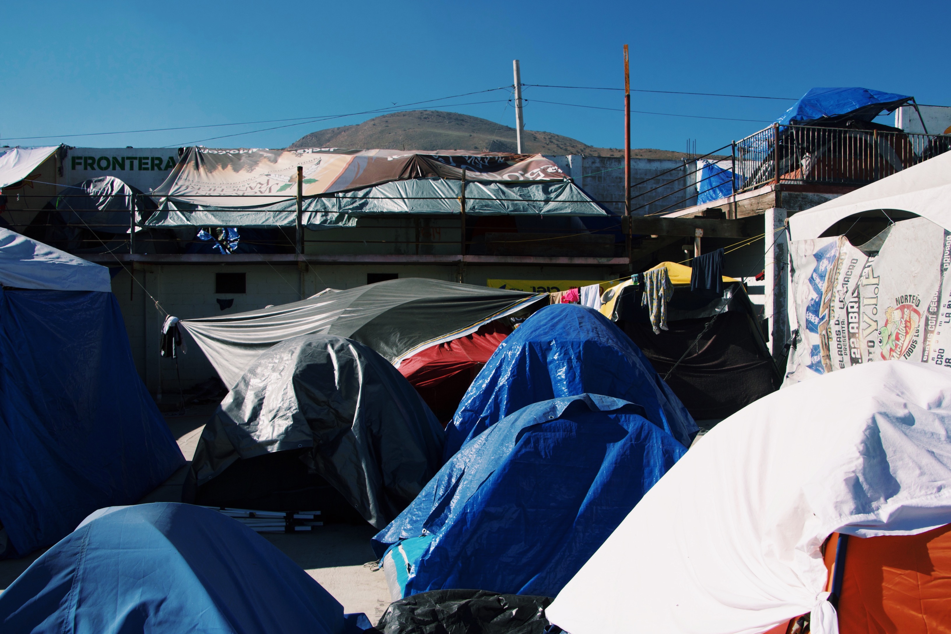 A collections of tents fills the courtyard inside El Barretal. Thousands of Central American migrants live on the pavement on the patio inside the unused nightclub in Tijuana, Mexico.