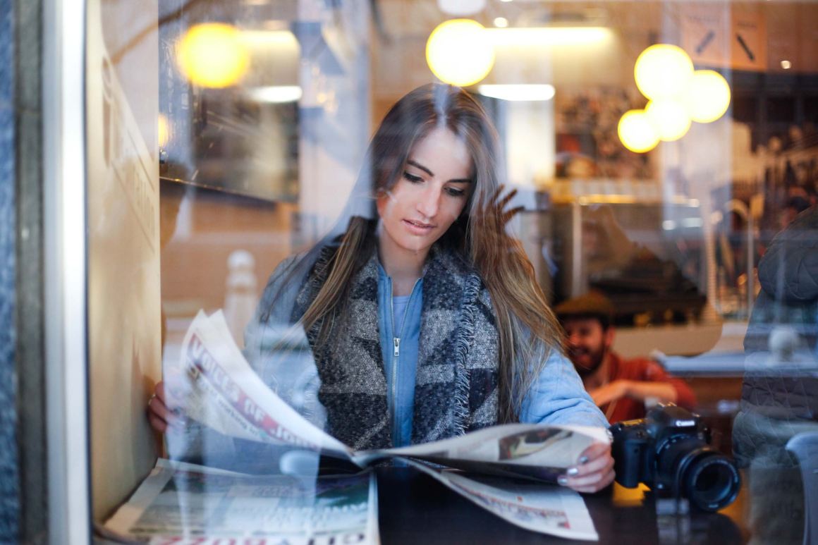 Woman reading newspaper news media