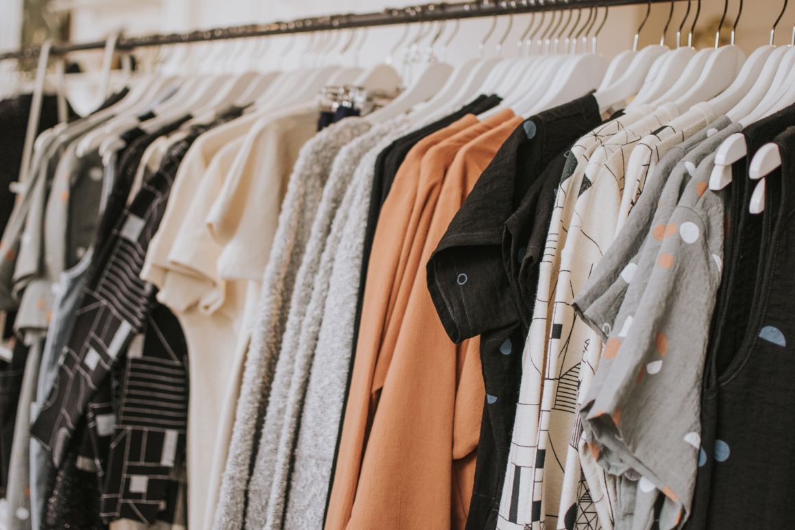 Women's clothes hang on a rank in a clothing store.