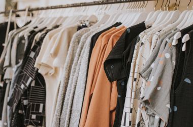 Women's clothes hang on a rank in a clothing store.