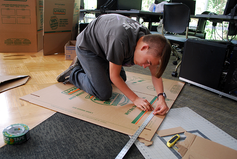 Sam Larson, 15, measures a section of his cardboard canoe during ANSEP's summer Acceleration Academy at the University of Alaska–Anchorage.