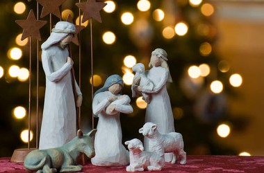 A depiction of the Nativity with a Christmas tree backdrop.