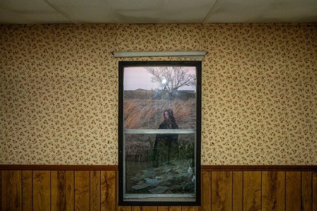 Georgia de la Garza, a local environmental activist in southern Illinois. She is pictured from inside an abandoned house near the Eagle River Coal Mines.