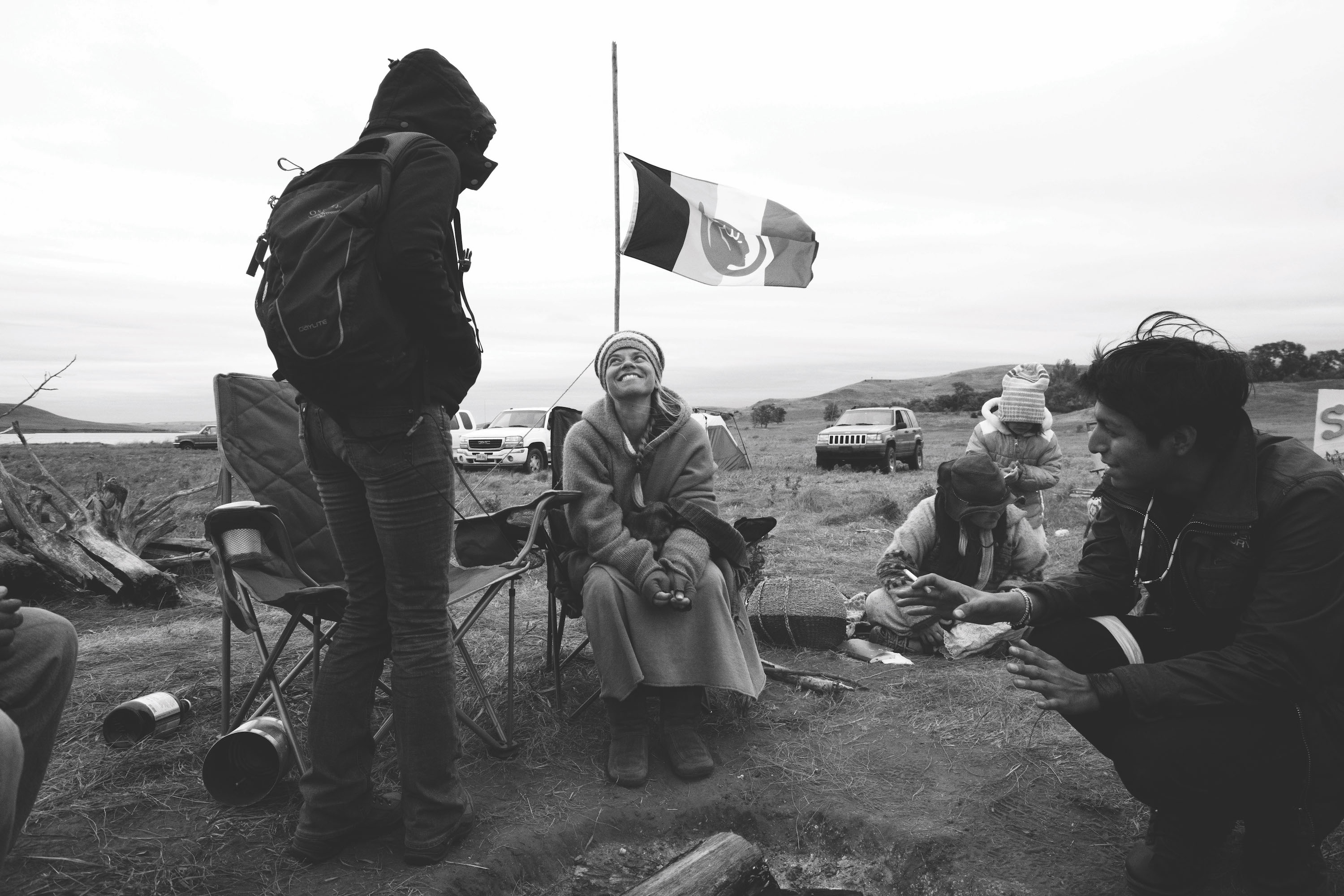 Mni Wiconi participants gather under an American Indian Movement flag.