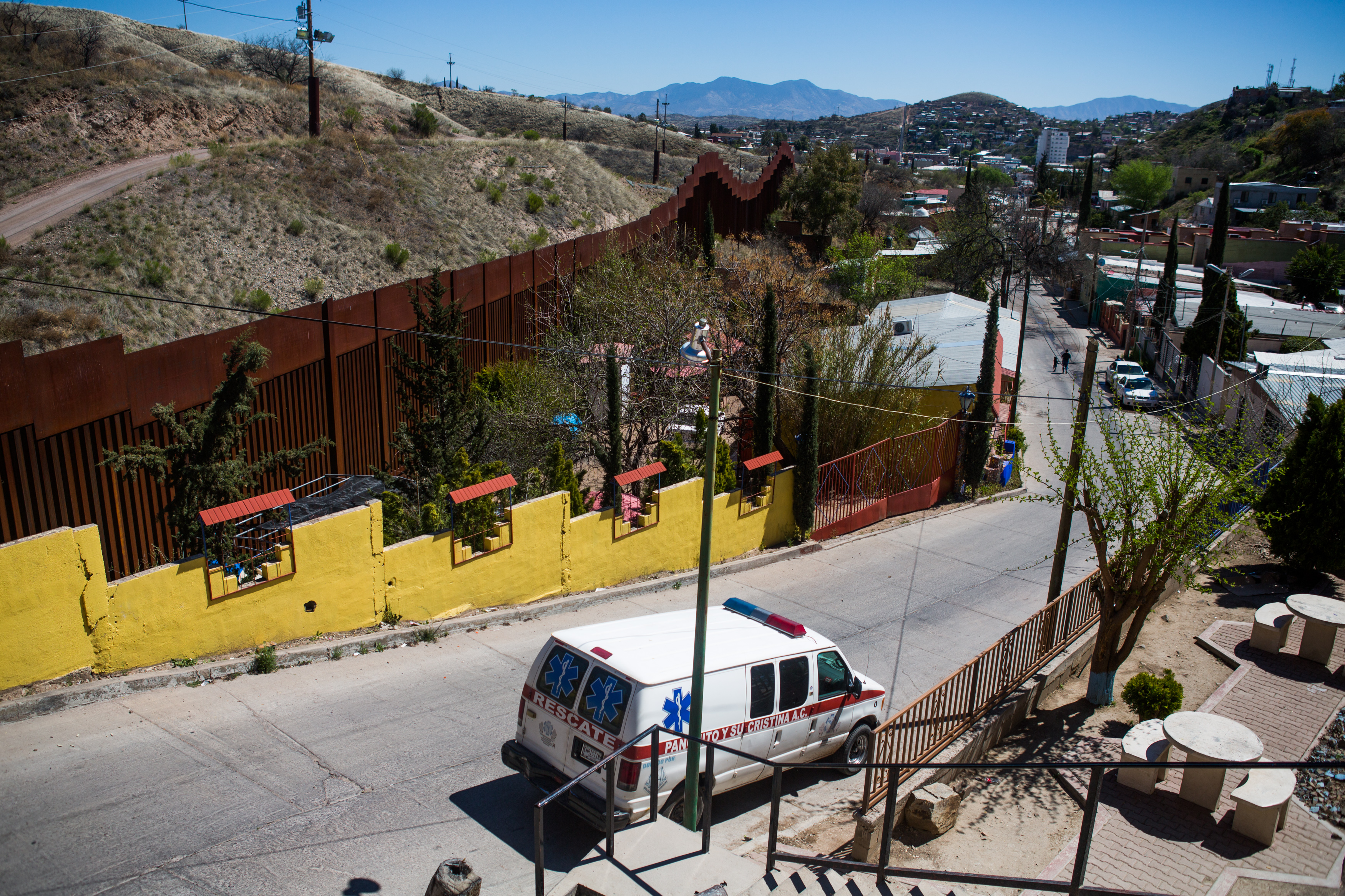 Panchito's ambulance sits parked alongside the border wall while he visits a women's shelter where several families are awaiting asylum.