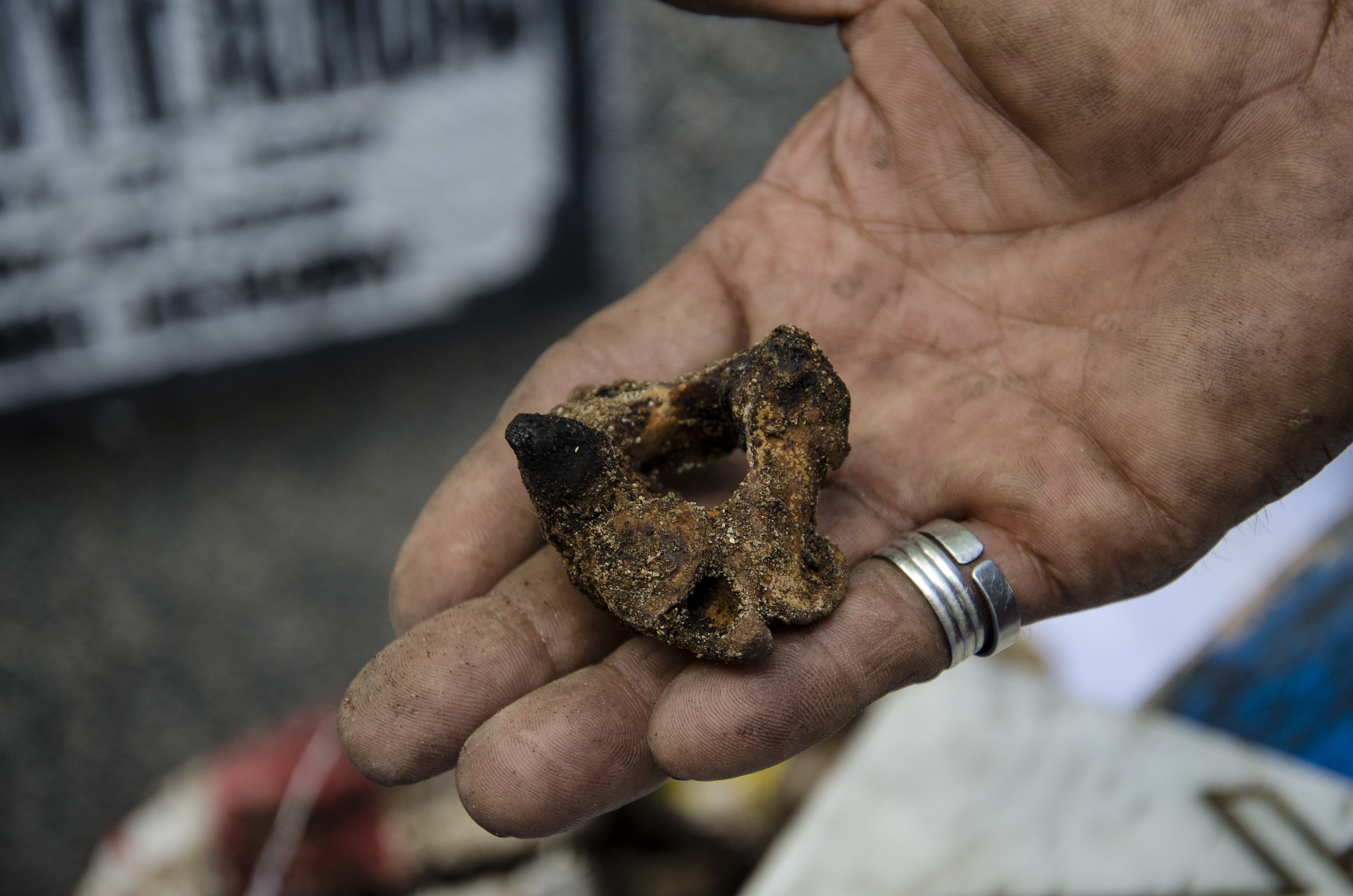 A gravedigger in Pasay cemetery holds the coccyx of an EJK victim allegedly killed by unidentified assailants wearing black masks.