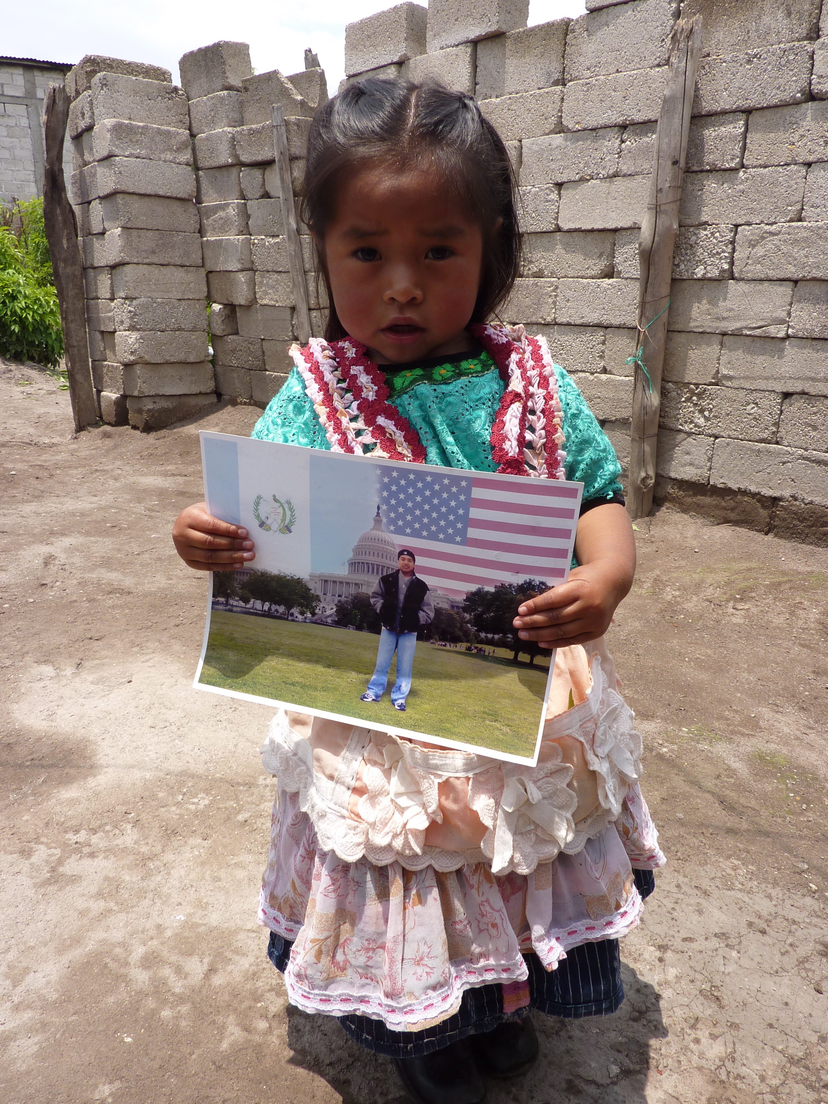 A young girl holds a photograph of her father, who died while trying to cross into the U.S.