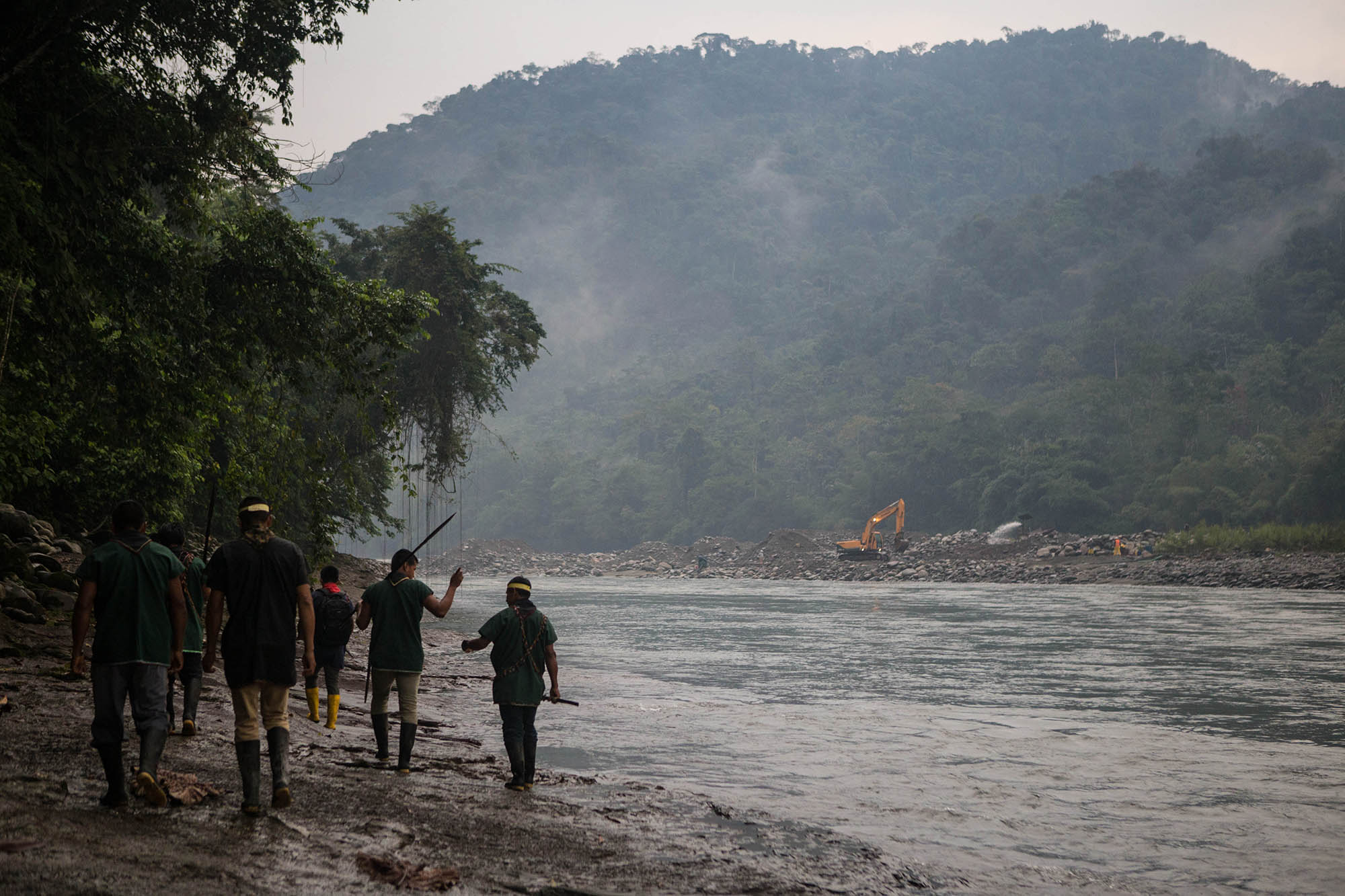 The Cofan guardia on one of their land patrols, watching as mining activities destroy the banks of the river on the other side.