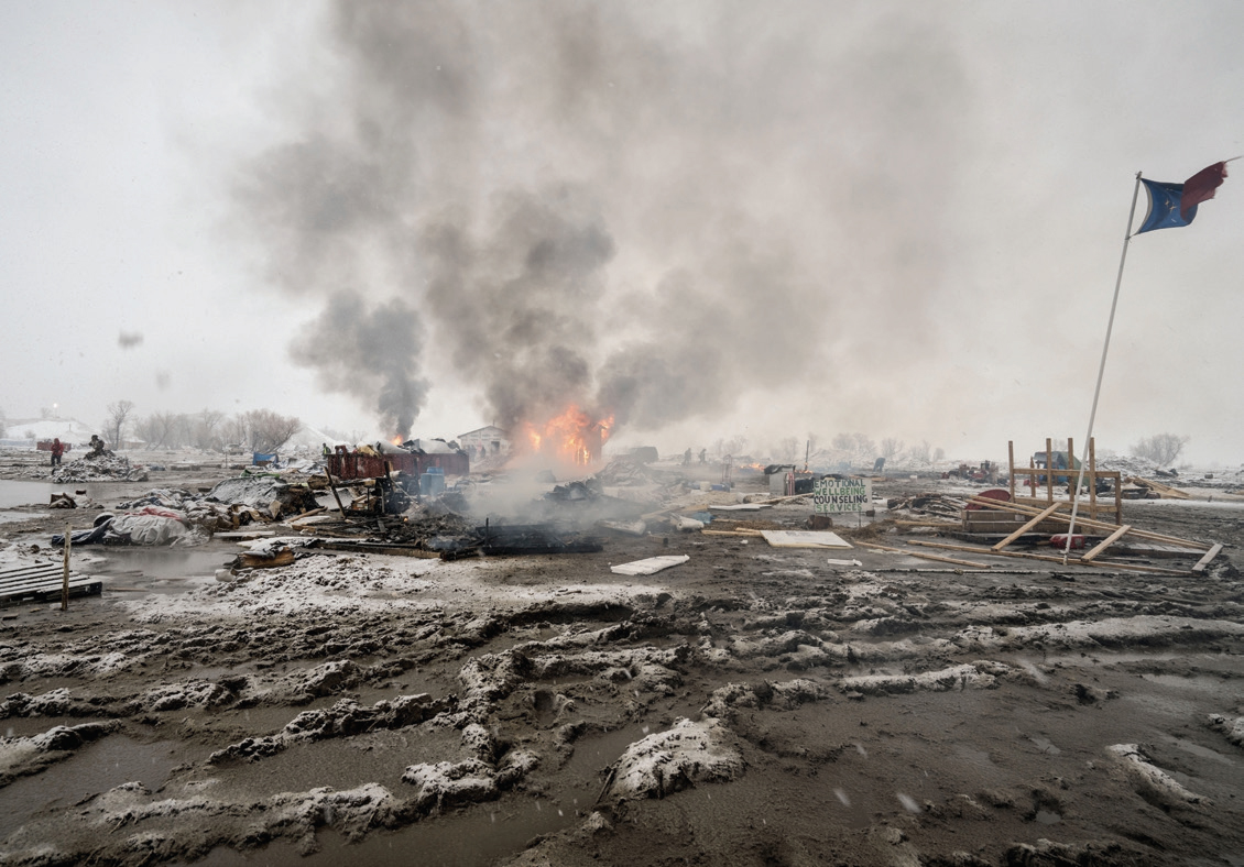 Activists departing the Dakota Access Pipeline protests burn their tents. Next month, we return to Standing Rock one year after the demonstrations.