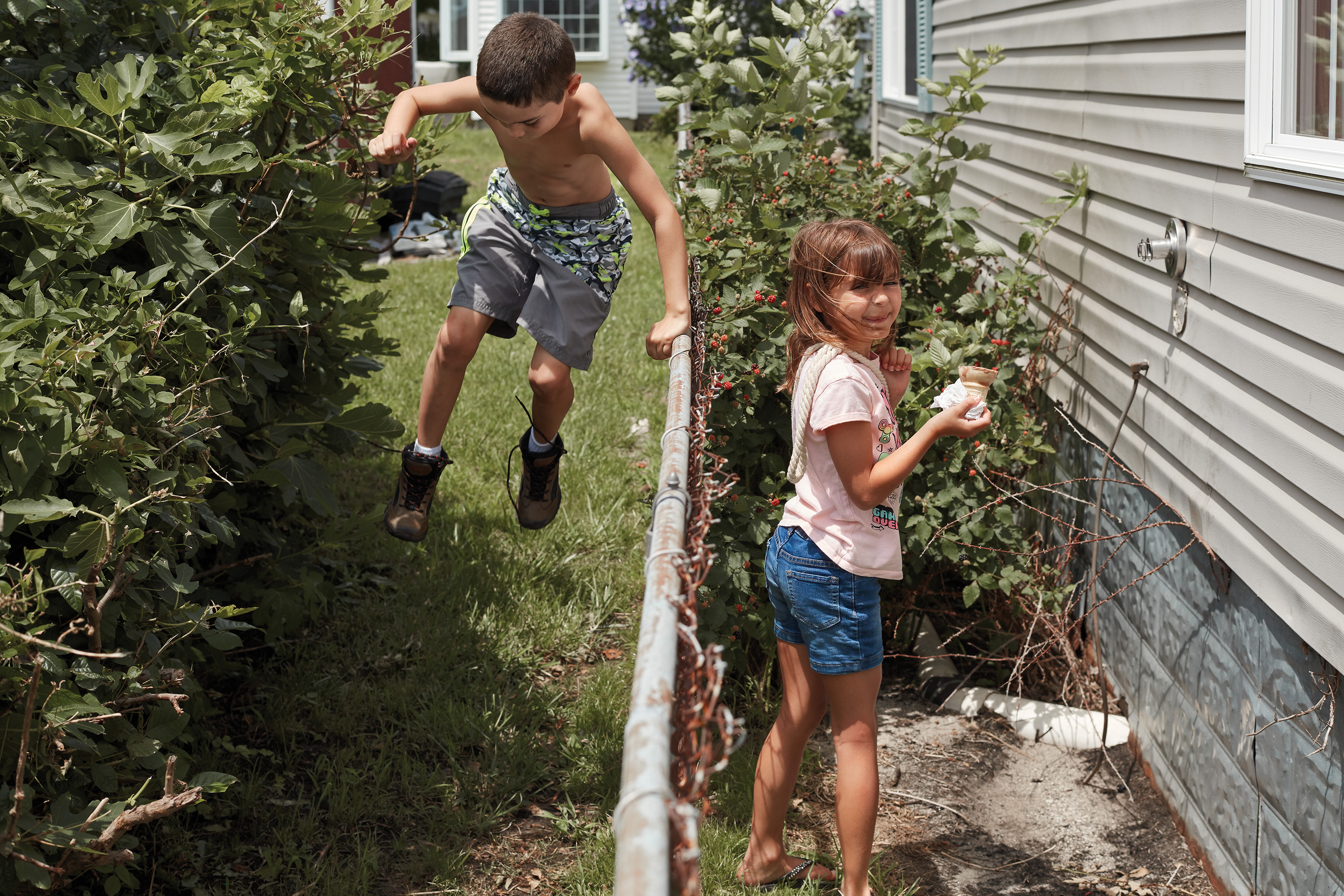 Cousins Wesley-Dean Tyler and Jordan Daley pick raspberries behind their grandmother's house on Tangier Island.