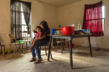 Berenise sostiene su hermano de dos años, Manuelito. Ella pasa mucho de su tiempo libre cuidando por su hermano menor. (Photo: Jerry Redfern)