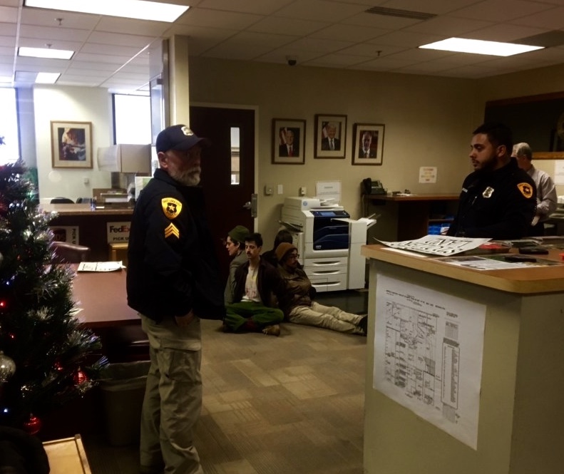 Police look on as the last remaining participants in the protest, who had announced they would leave once the BLM canceled the oil and gas lease sale, sit with arms linked.