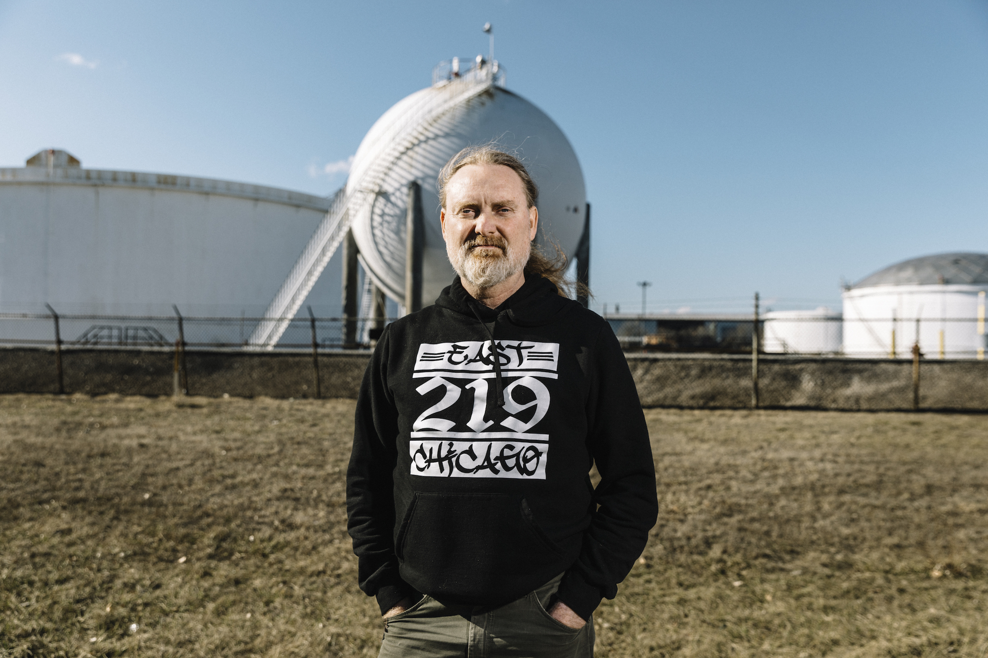 Thomas Frank, a community activist who works with the East Chicago Community Strategy Group, stands in front of storage tanks on the Buckeye Pipeline property in the New Addition district of East Chicago. Frank describes the community group as an 